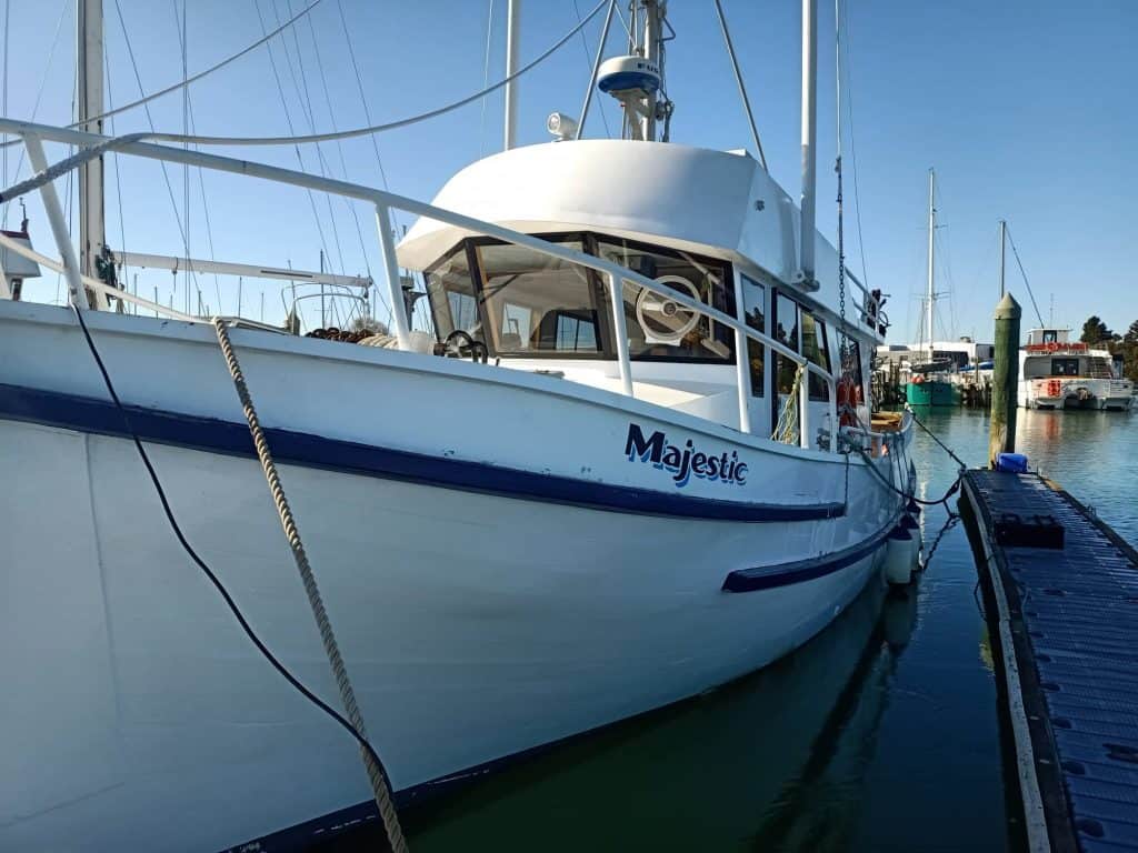 View of the boat Majestic tied to its berth in Motueka Marina.