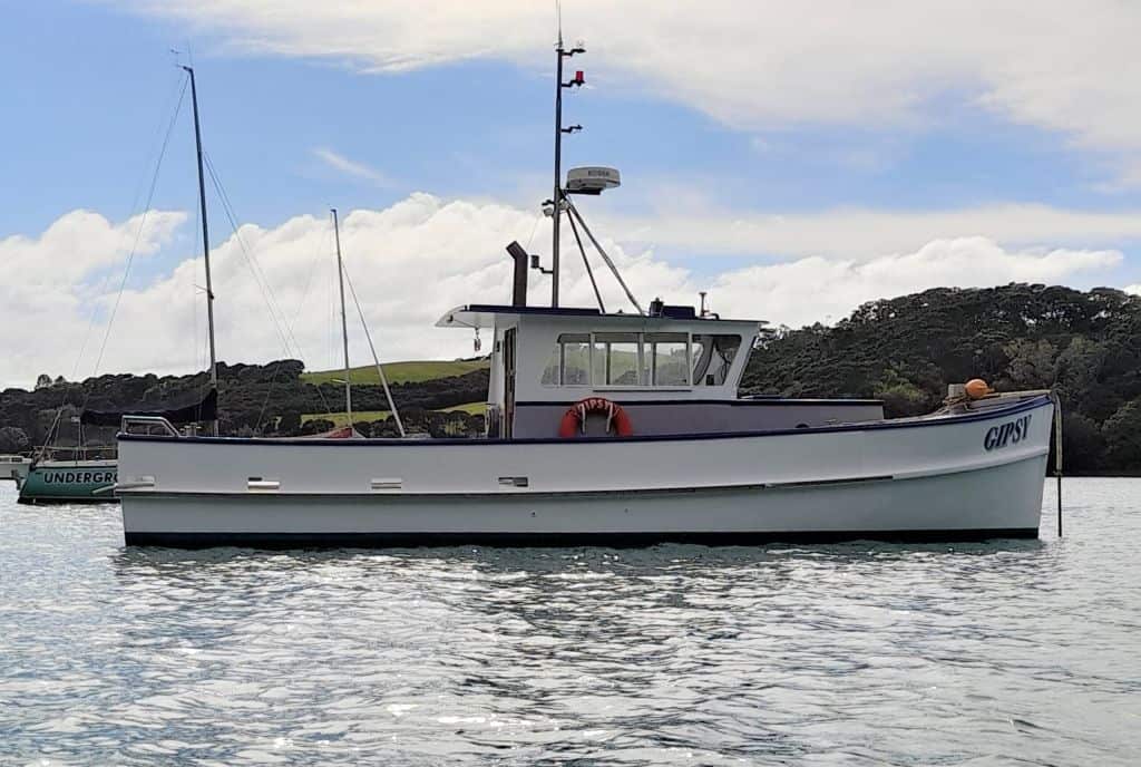 Side view of Gipsy on a mooring. Gipsy is a wooden boat.