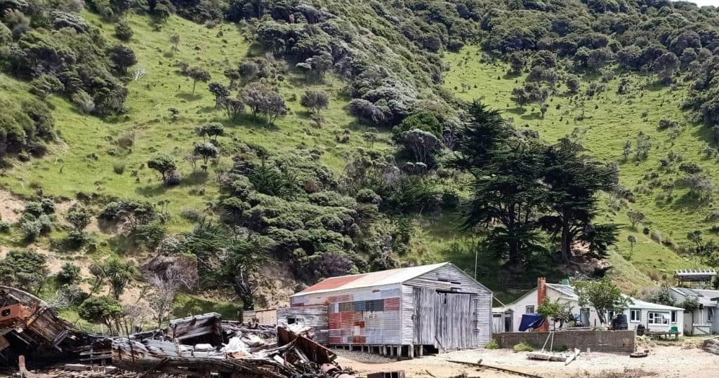 View of Wakatahuri Boatshed with the wreck of Tia Roa beside it