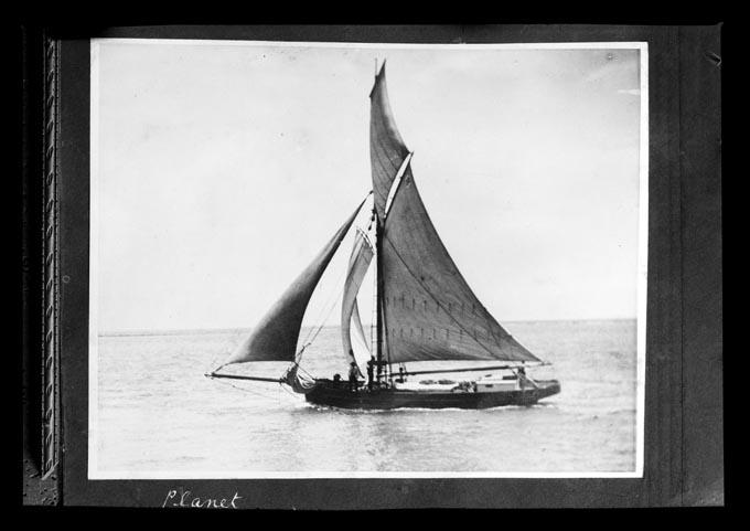 Black and white image of the sailing ship Planet, seen side on and sailing.