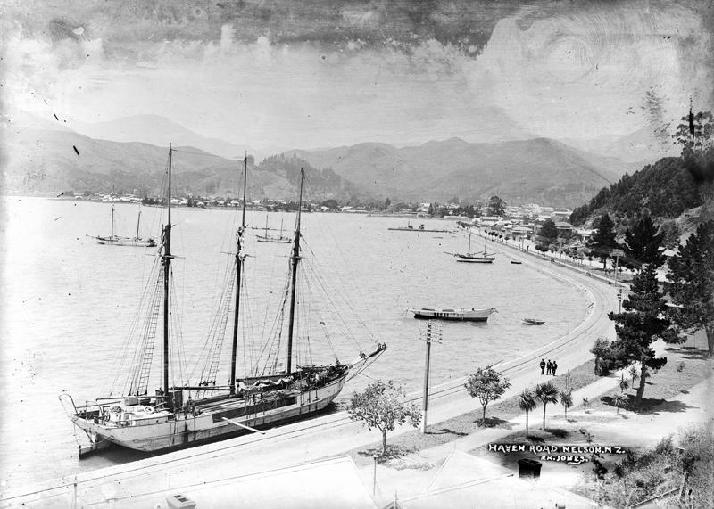 Black and white image of the scow Southern Isle tied to a wharf at the side of a road