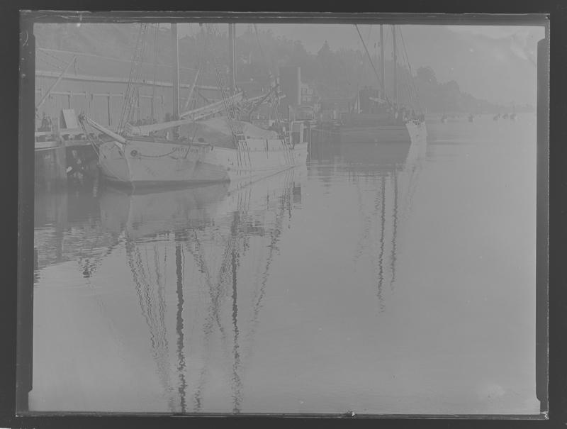 Black and white image of the scow Pearl Kasper tied to a bank.