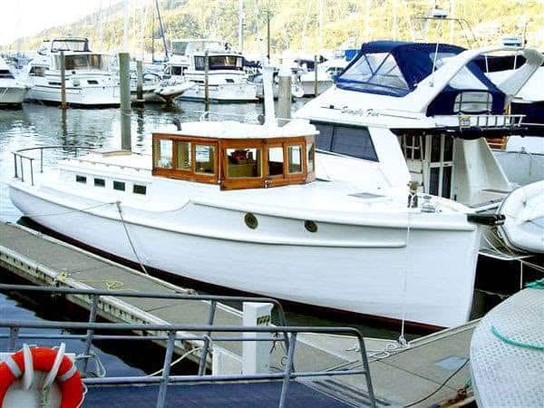 Southern Maid Colour image of the boat Southern Maid in a berth at a marina. Other boats and marina piles can be seen in the background.