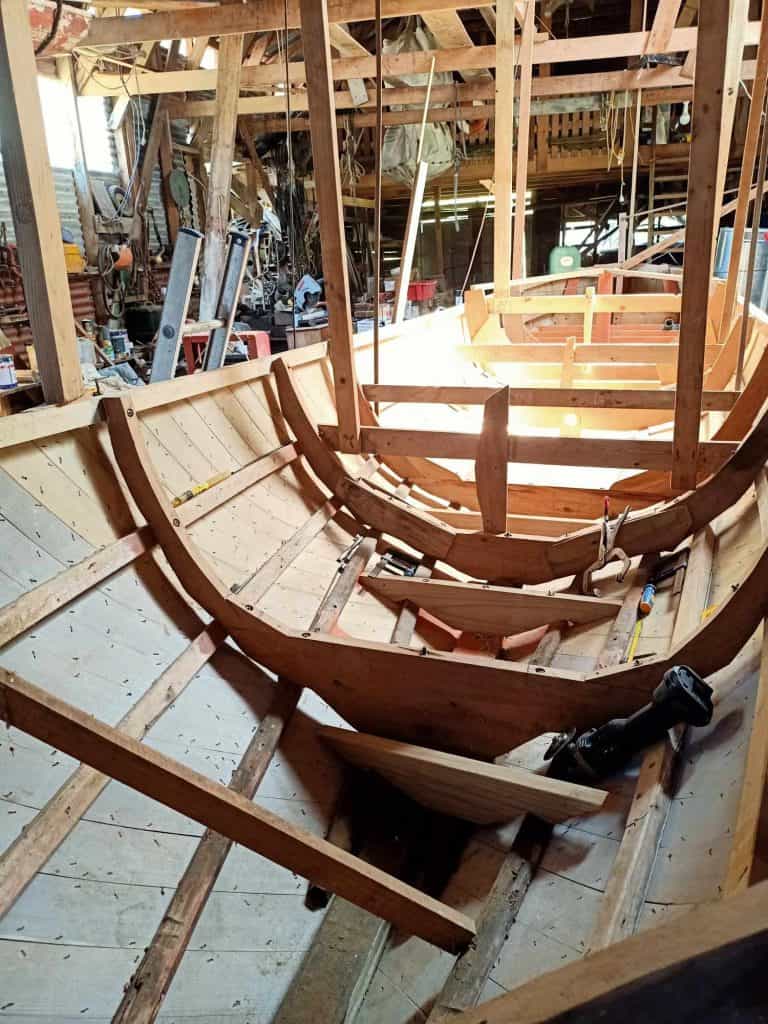 View of the boat Tanekaha inside the boat shed at Wakatahuri. Looking inside the hull which being rebuilt.
