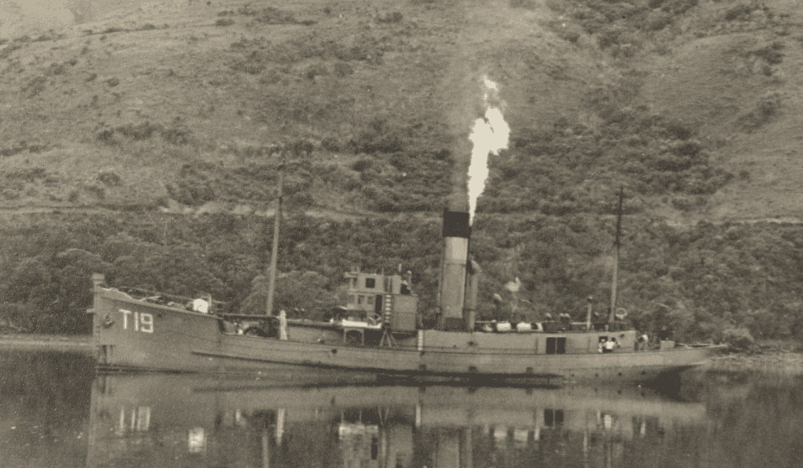 Black and white image of the minesweeper Manuka seen from the side with smoke coming out of its funnel