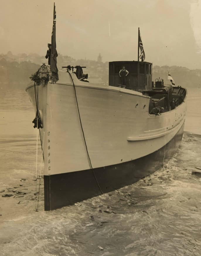 Black and white image of the minesweeper Tawhai on launch day. seen from the bow the boat is in the water.